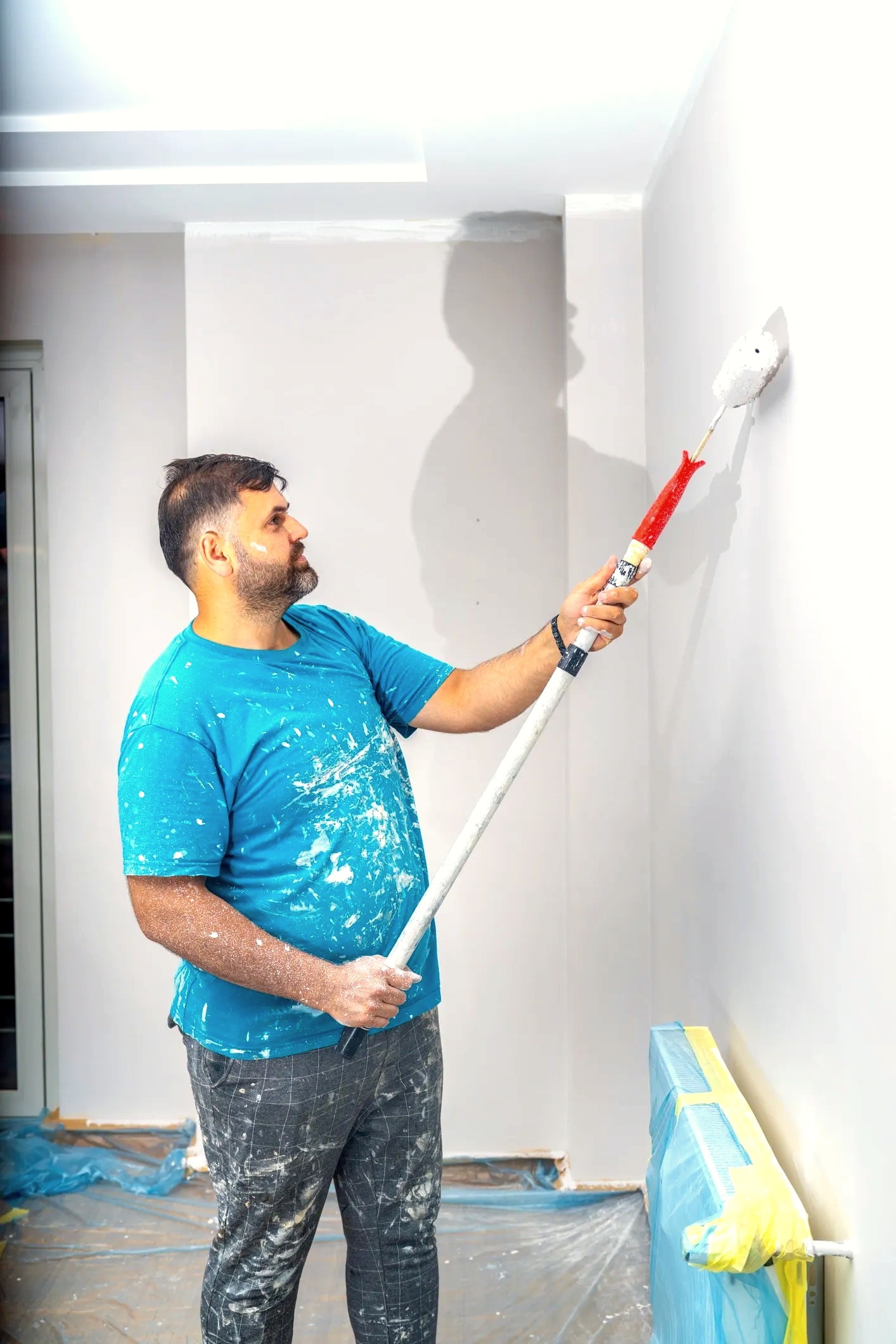 Professional painter rolling interior wall